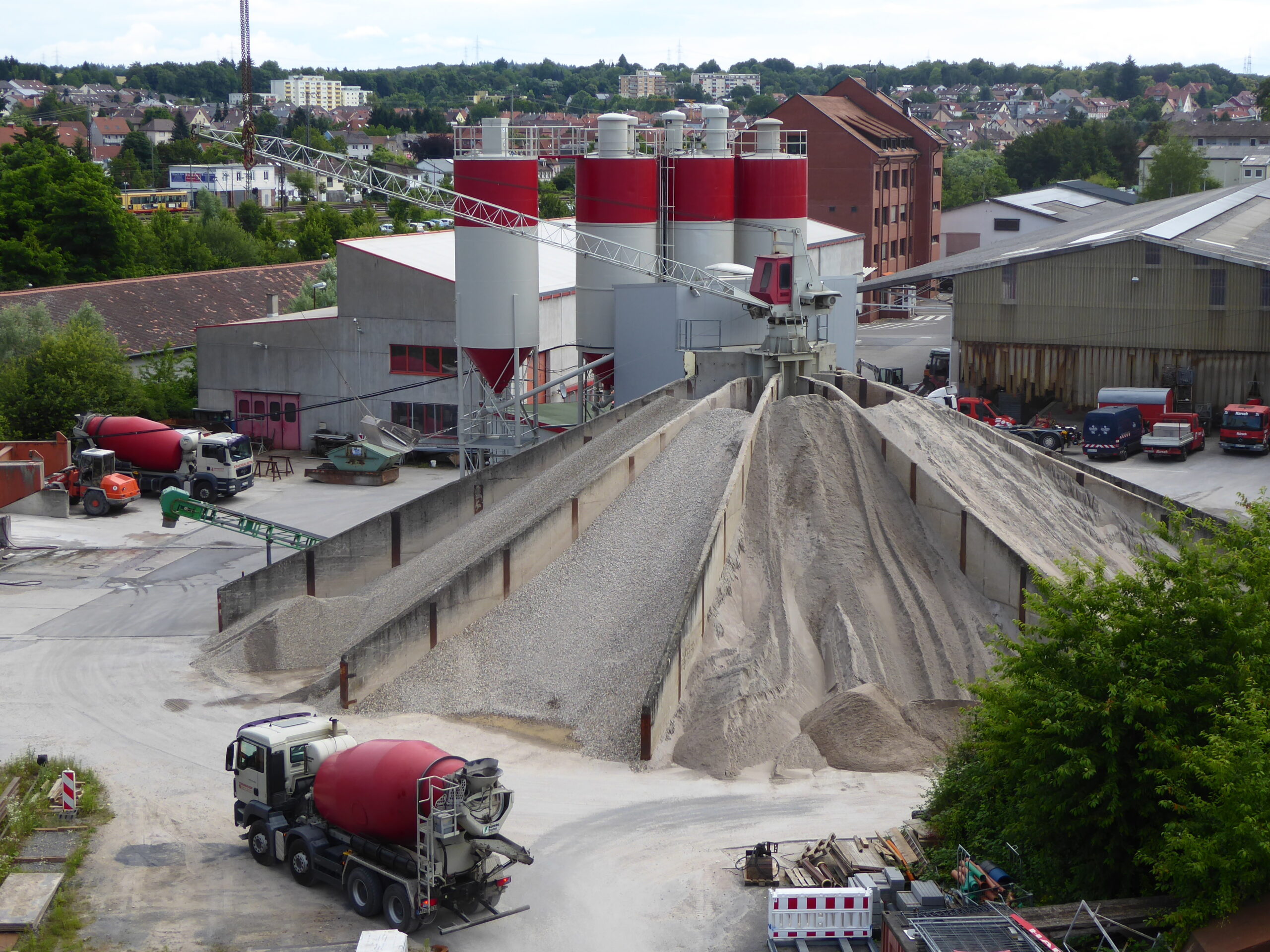 Transportbetonwerk mit Zuschlagstoffhalden, Siloanlagen und Betonmischfahrzeugen